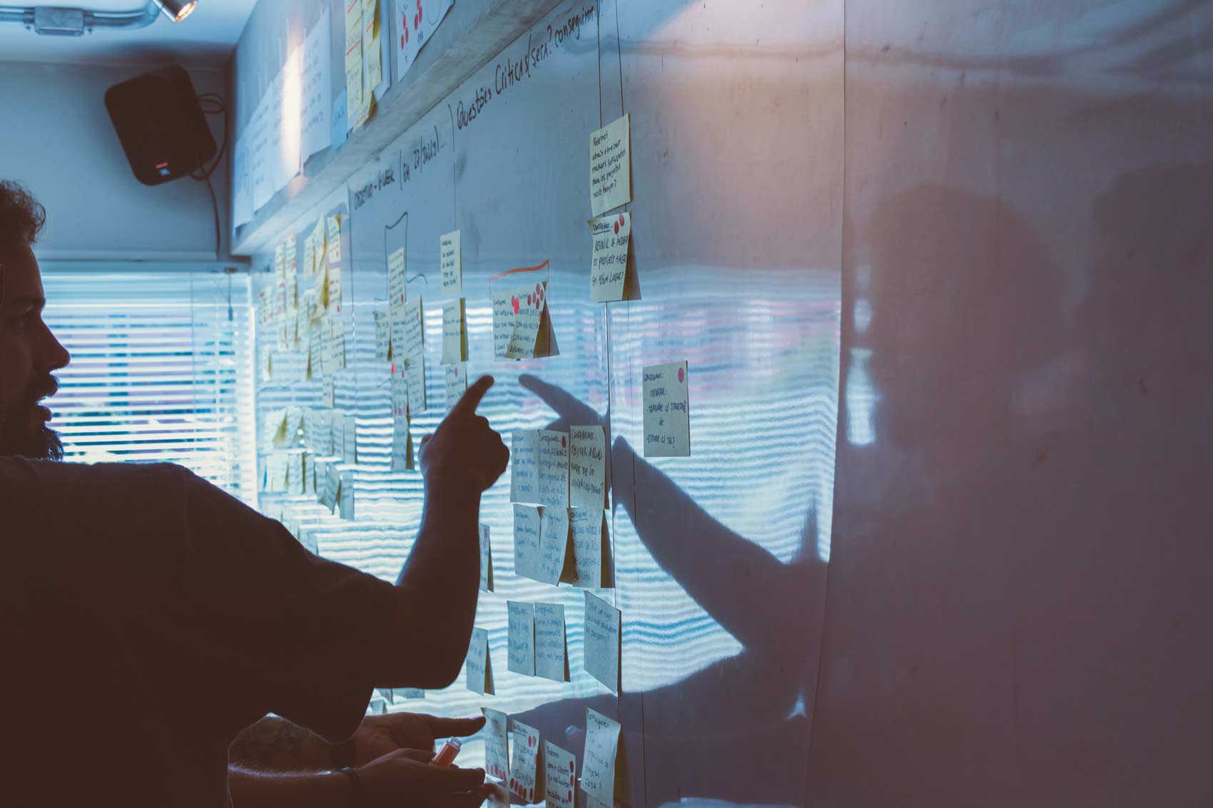 Person pointing at whiteboard with sticky notes
