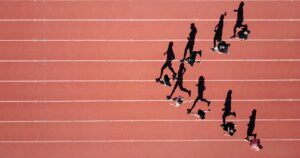 Ariel view of track runners, running in a horizontal v formation towards the centre of the image.