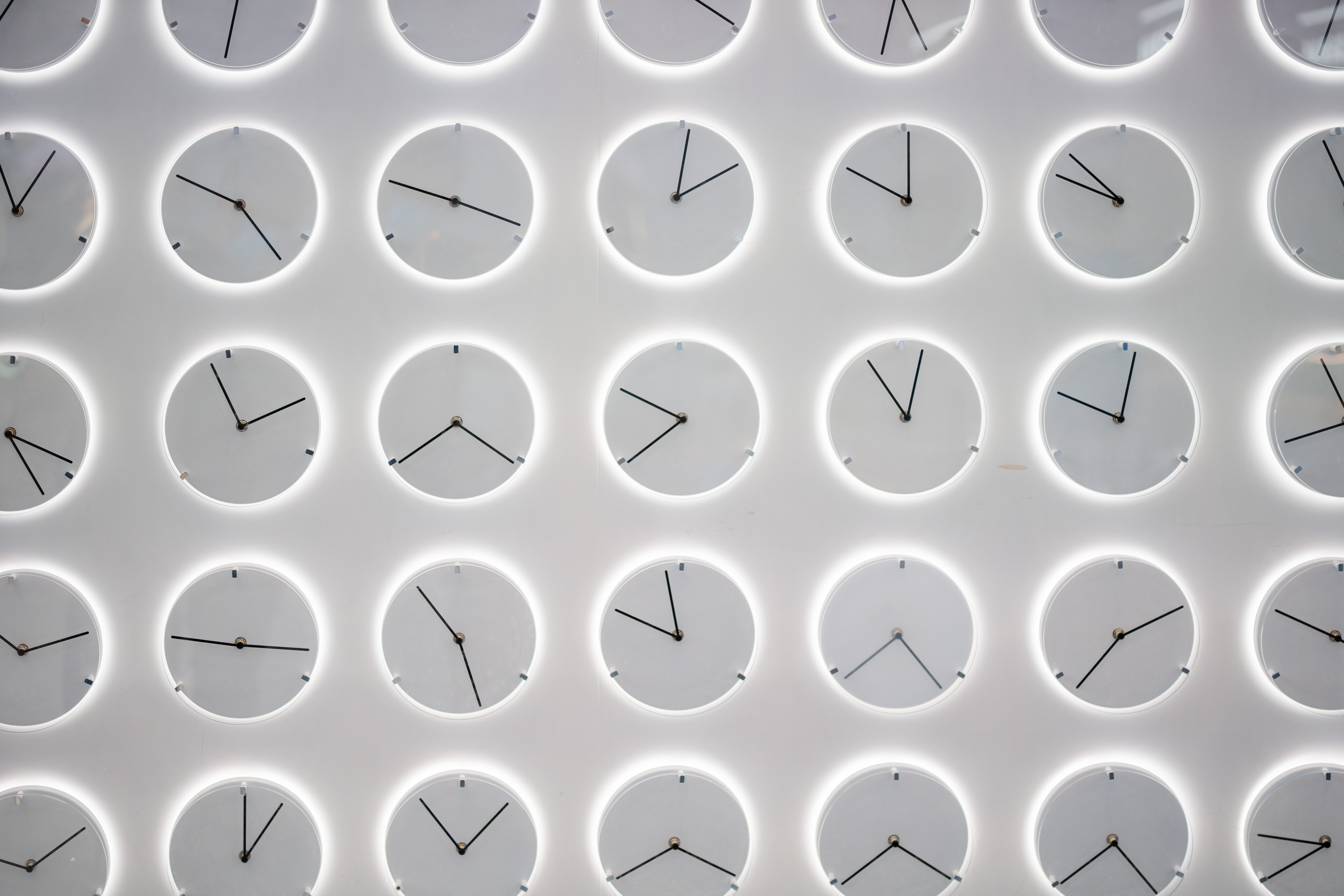 Several clocks with different times shown on each on a white background